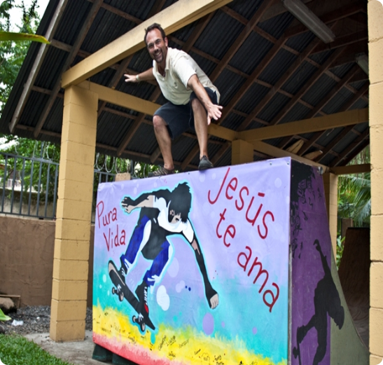 A man on a skateboard jumping over a wall.