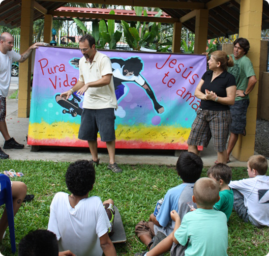 A group of people sitting around watching an outdoor performance.