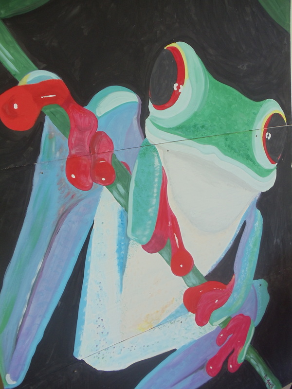 A painting of a frog with red eyes.