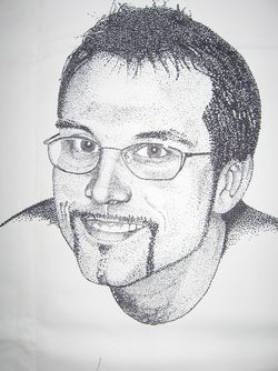 A man with glasses is smiling for the camera.